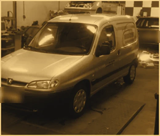 Bestelbus op de vloer van de werkplaats van Hidzer Autoservice, in straatlichtkleur